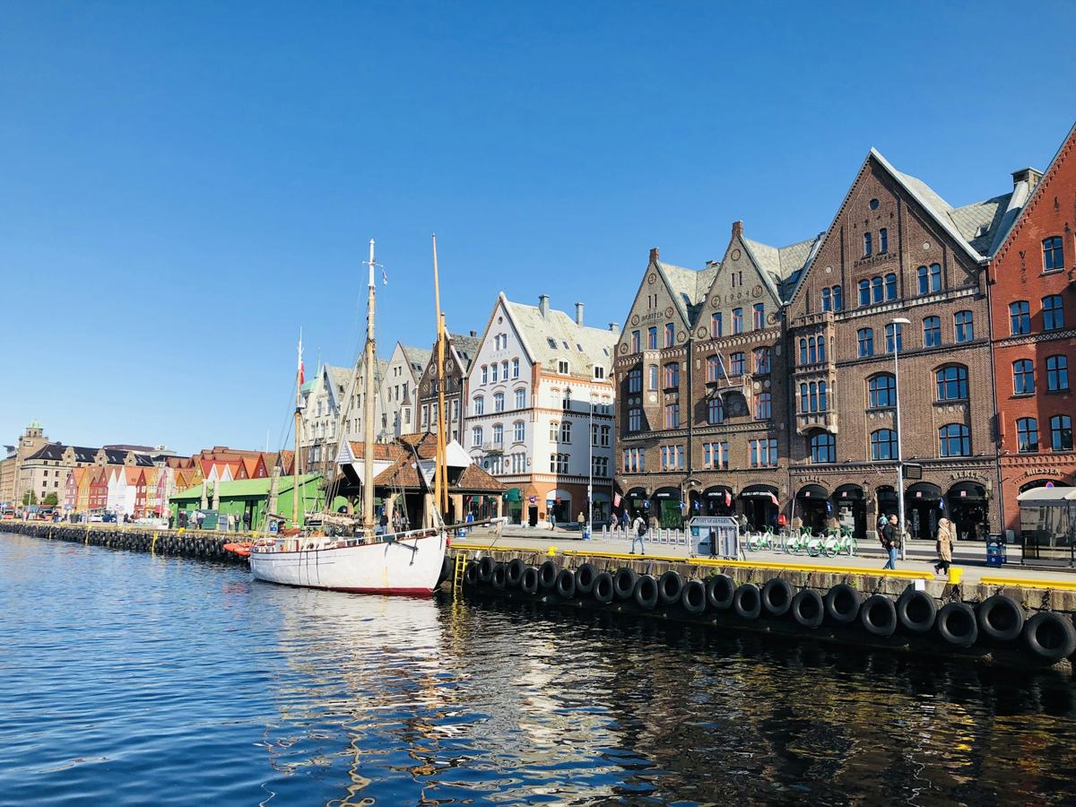 A wooden sailboat moored in Bergen harbor in front of old trading houses