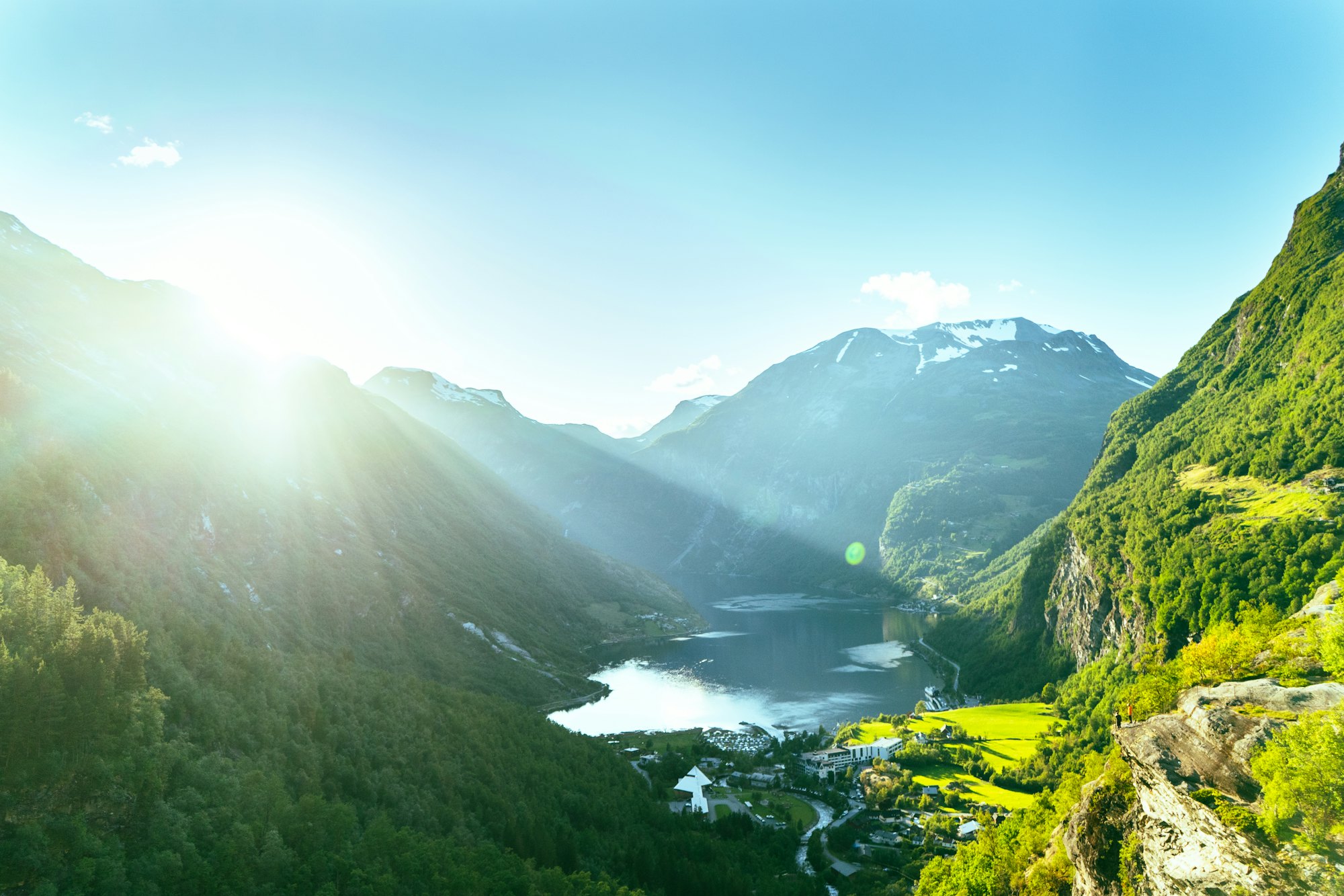 Sunlight over a green mountain valley and fjord